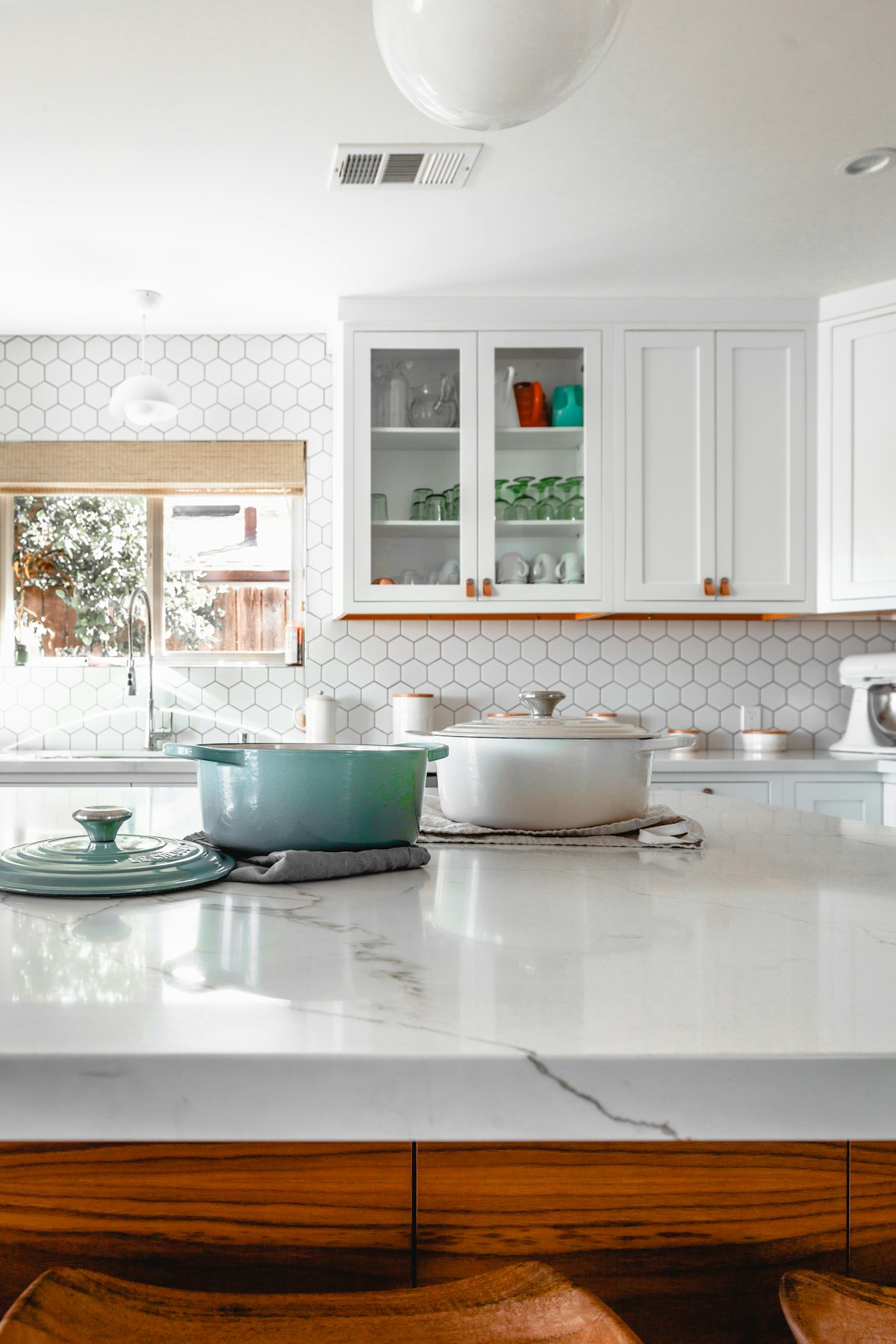 White kitchen with hexagon tile and a marble island